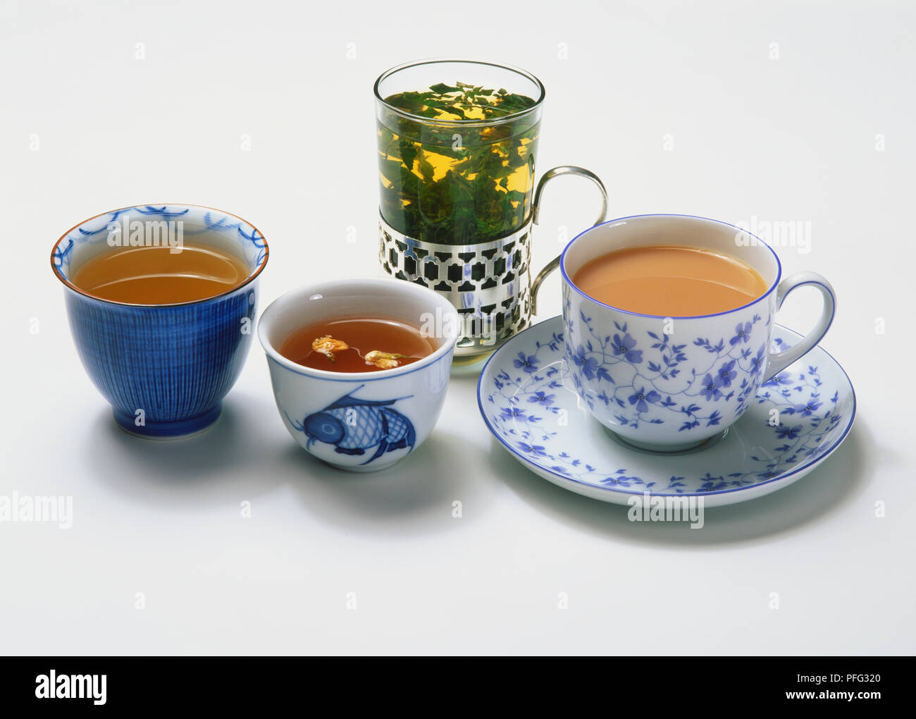 Porzioni di erbe, il verde e il tè nero in una varietà di tazze e bicchieri. Foto Stock