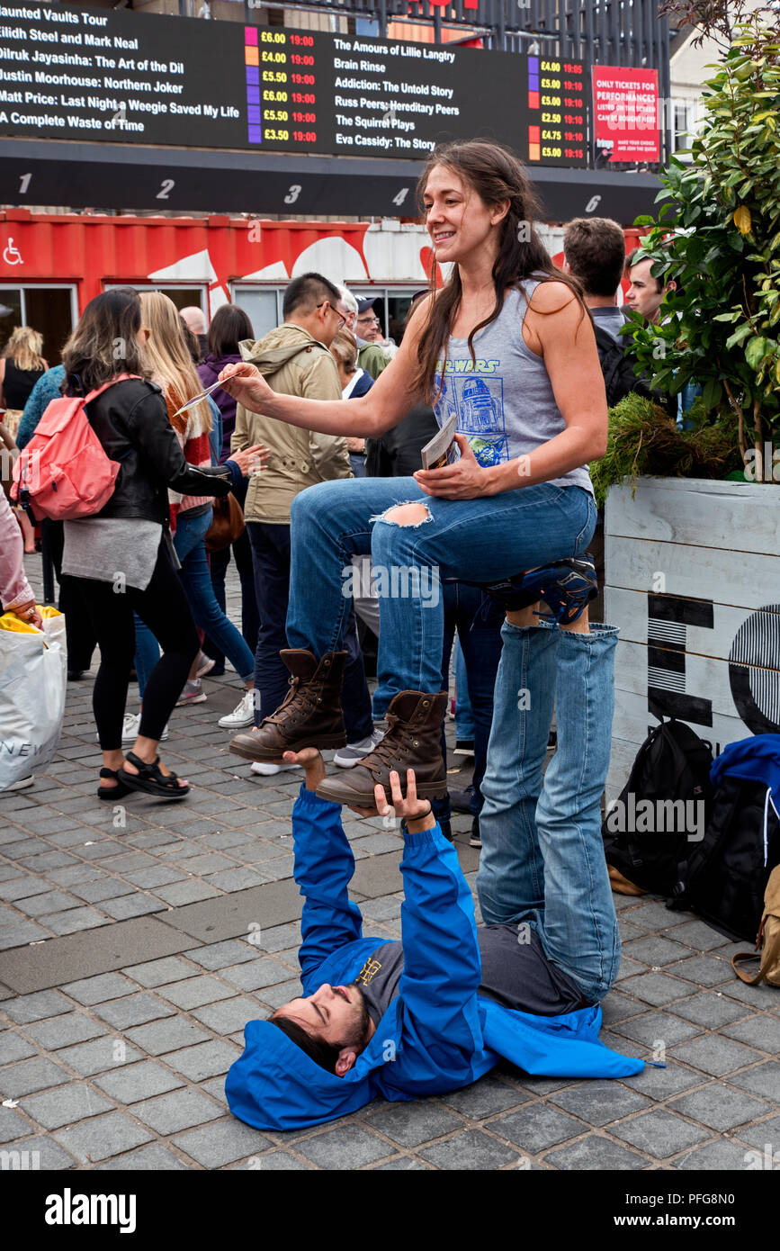 Una giovane donna conun nuovo modo di attirare attenzione in quanto essa promuove una mostra in Edinburgh Fringe Festival presso il Tumulo. Foto Stock