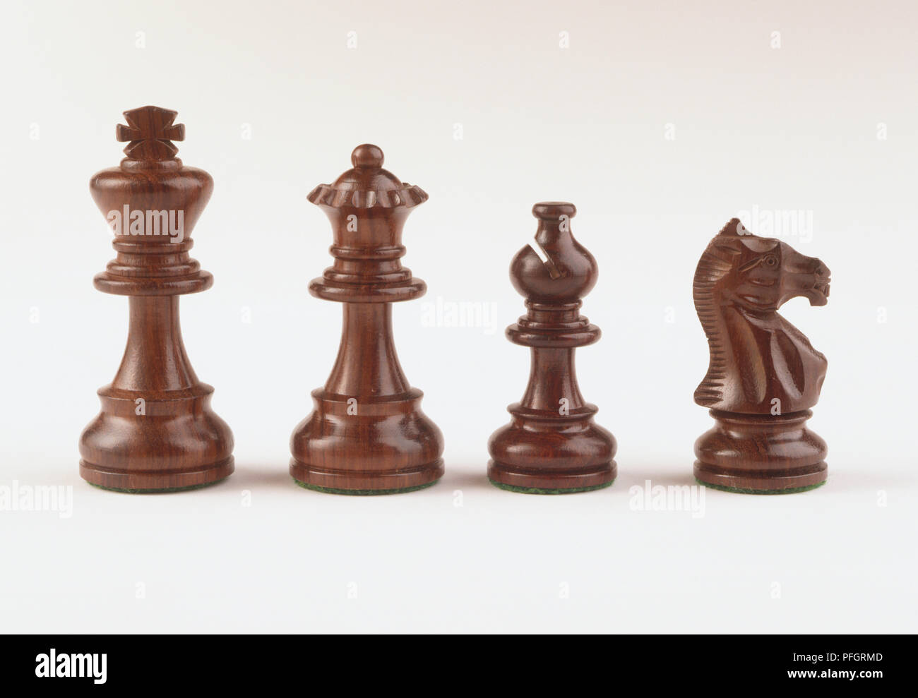 Quattro al marrone scuro e legno di pezzi di scacchi, Re, Regina, Vescovo, cavaliere. Foto Stock