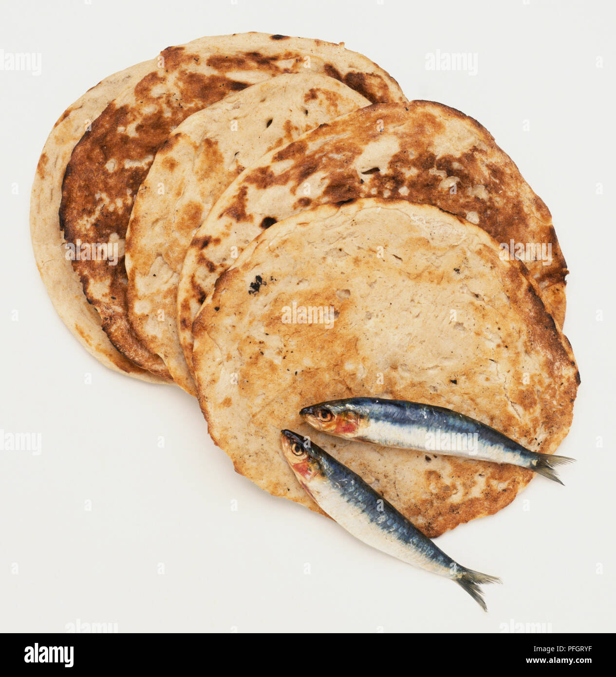 Cinque round le fette di pane e due piccoli pesci, vicino. Foto Stock