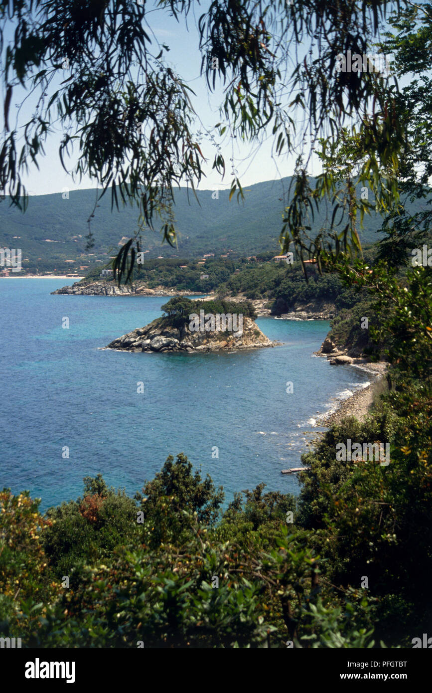L'Italia, Toscana, Isola d'Elba, Marciana Marina, sulla costa con ombrosi spiagge e insenature e isola-come il mare di pile. Foto Stock