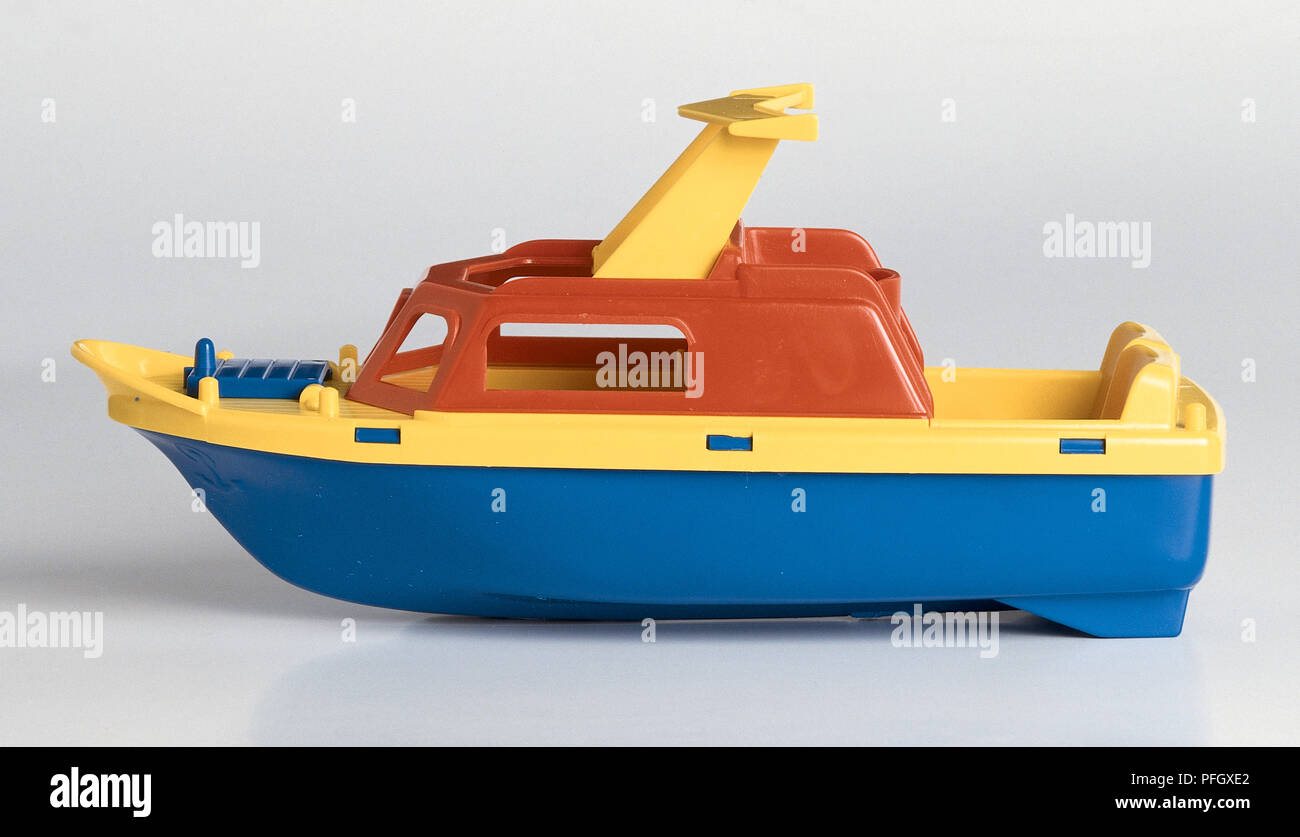 Una barca di plastica, colorato di rosso, giallo e blu. Foto Stock
