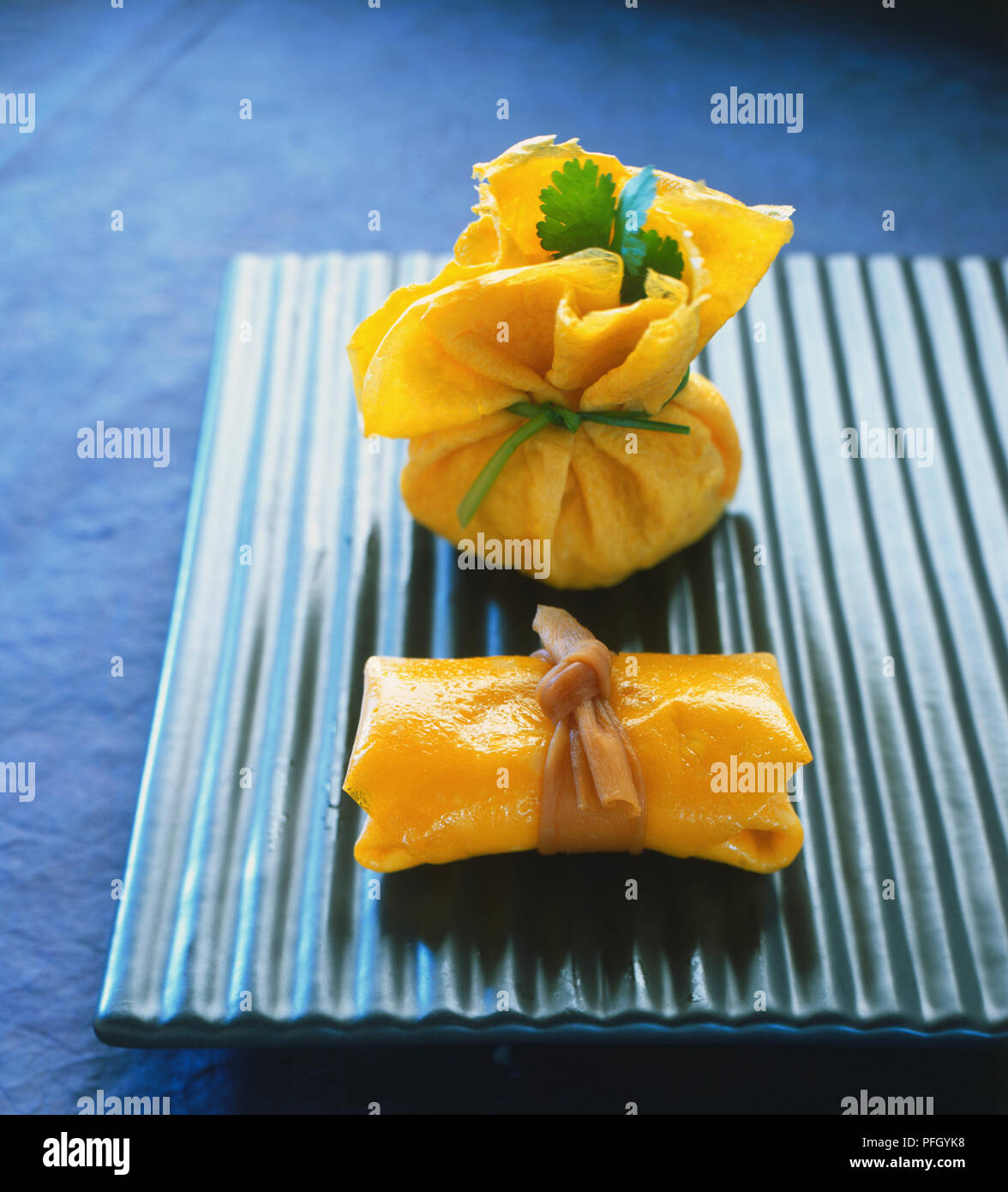 Frittata con due pacchi sul vassoio ondulato, vicino. Foto Stock