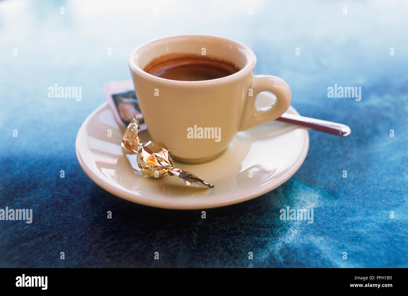 Tazza di caffè espresso, servita con zucchero e dolce sul piattino, close-up Foto Stock