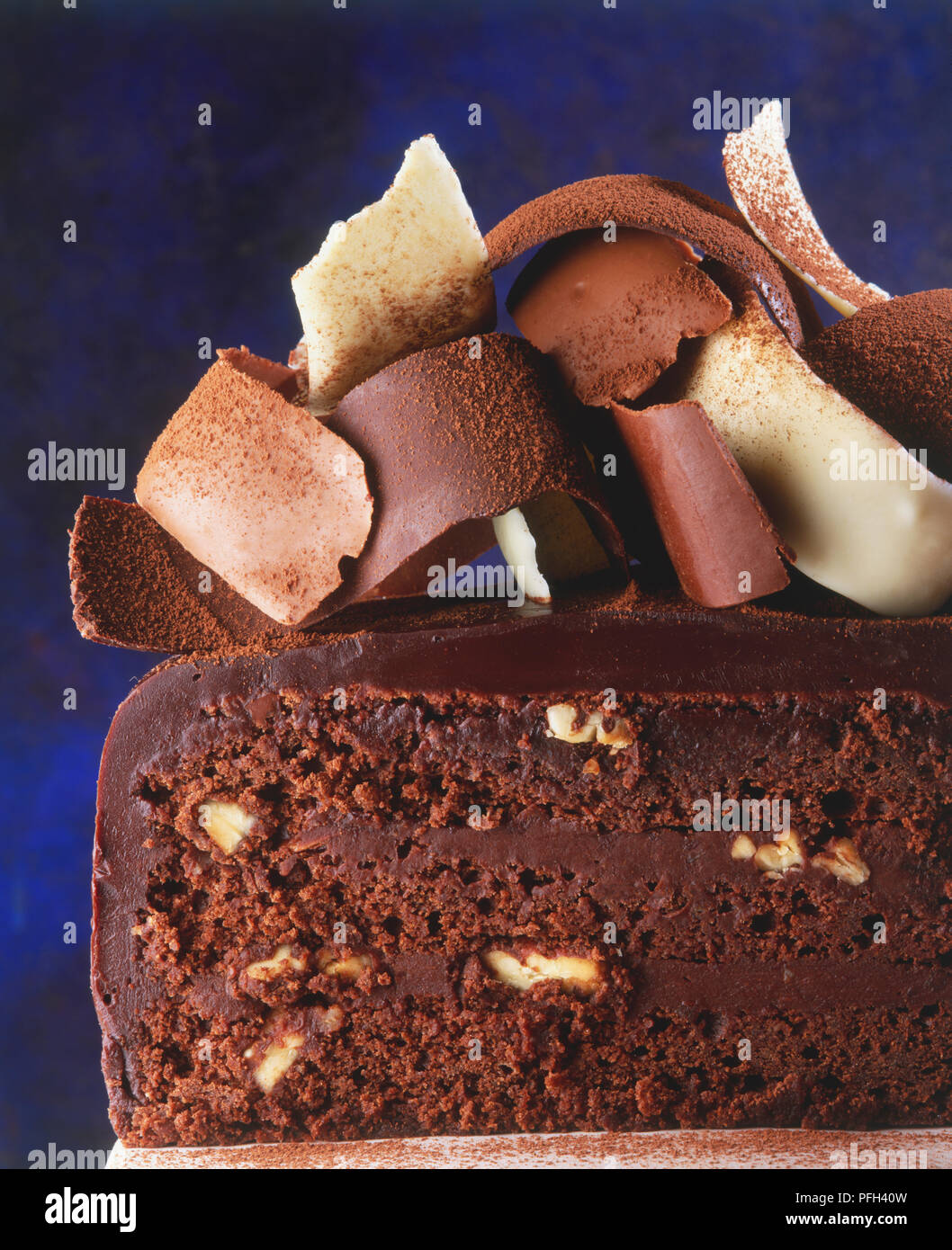 Fetta di iced torta al cioccolato guarnita con i riccioli di cioccolato, vista laterale, vicino fino Foto Stock