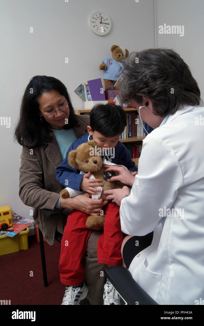 Ragazzo sulla donna di giro, medico donna holding stetoscopio per teddy Foto Stock
