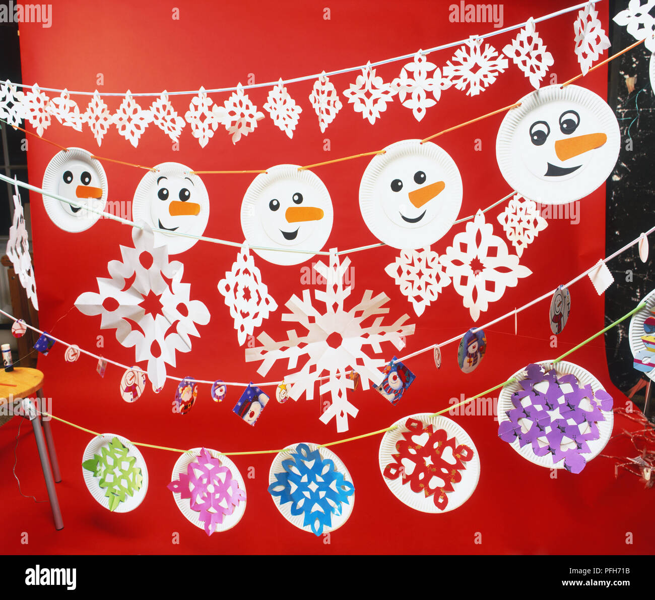 Linee di tagliare la carta decorazioni di Natale, compresi pupazzo di neve si affaccia su piastre di carta Foto Stock