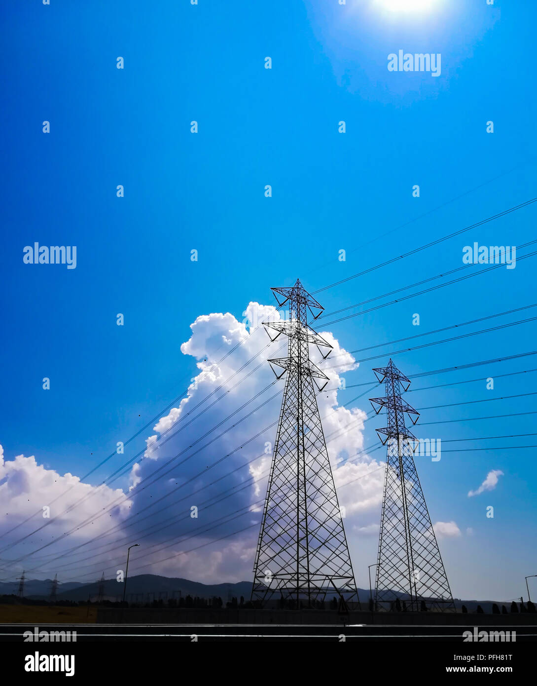Pilone di elettricità a basso angolo di vista contro il cielo blu e il cloud computing Foto Stock