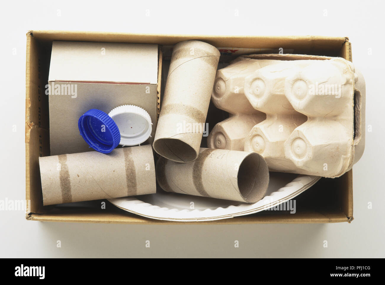 Casella di uovo, tubi di cartone, piastre di carta, coperchi in plastica in una scatola, vista da sopra Foto Stock