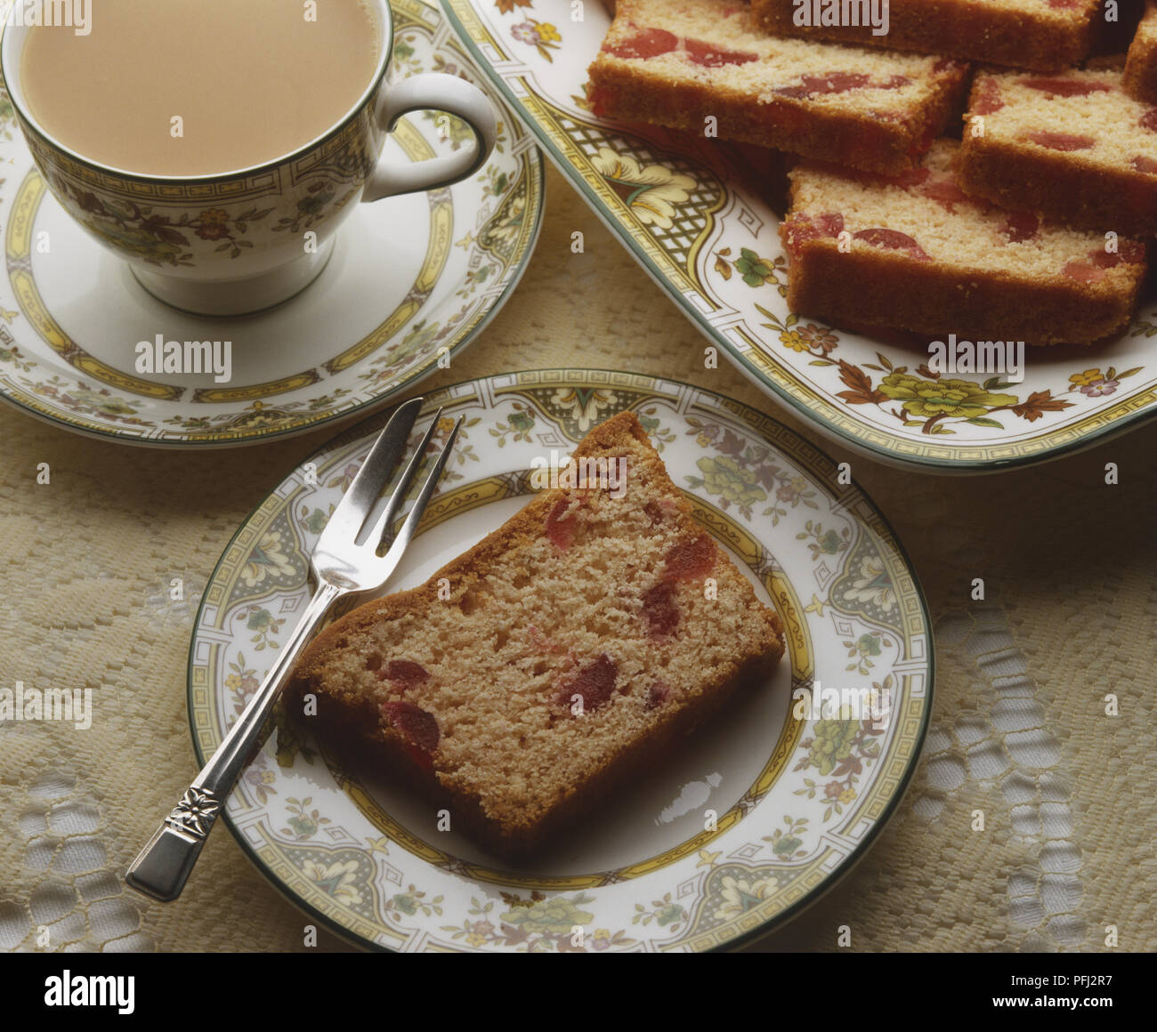 Fette di ciliegia Madera la torta su un piatto di portata, singola fetta su un piatto da dessert e una tazza di tè, close up, vista da sopra Foto Stock