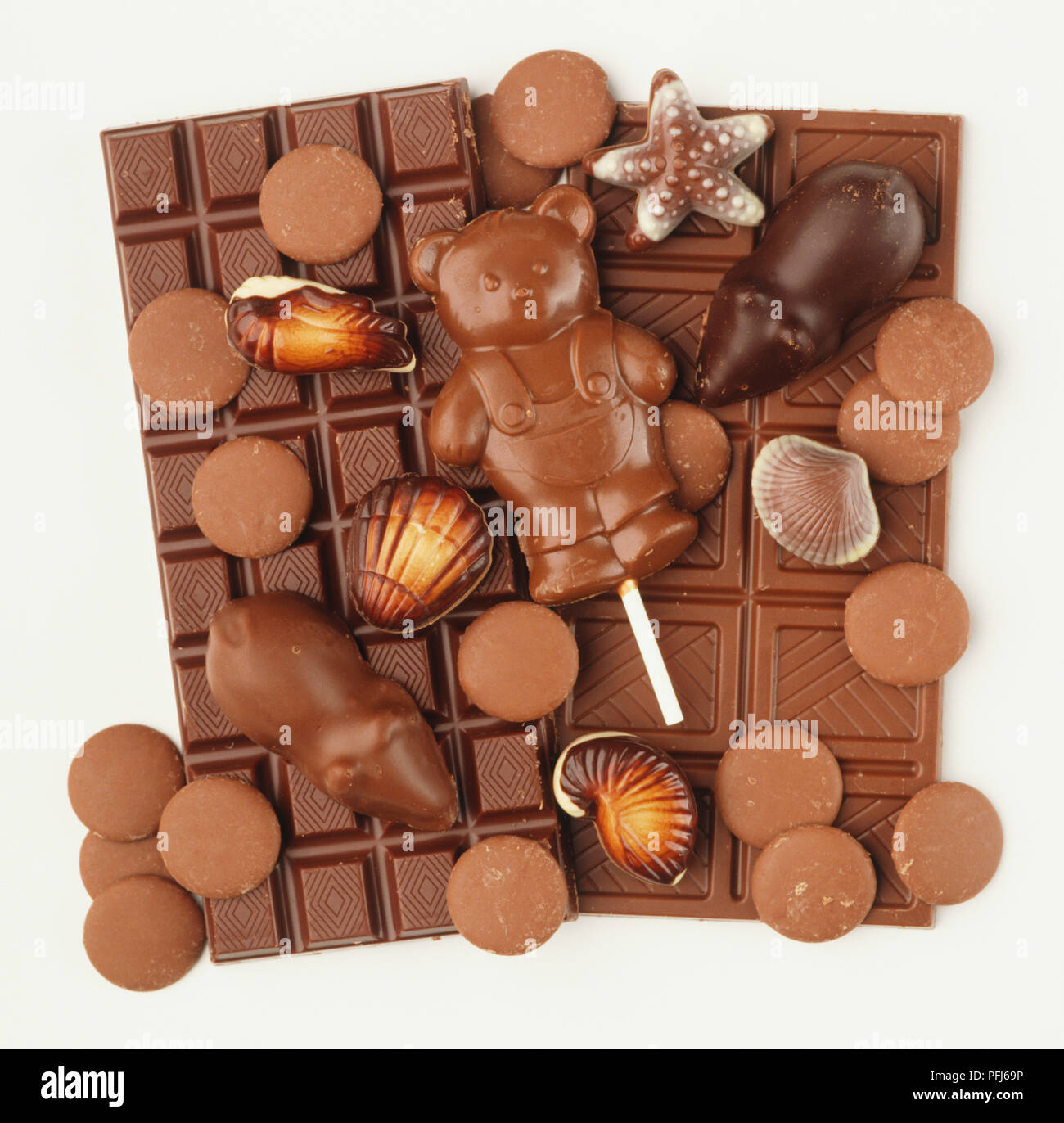 Il cioccolato al latte in forma di barre, gocce, lecca-lecca, mouse e conchiglie Foto Stock