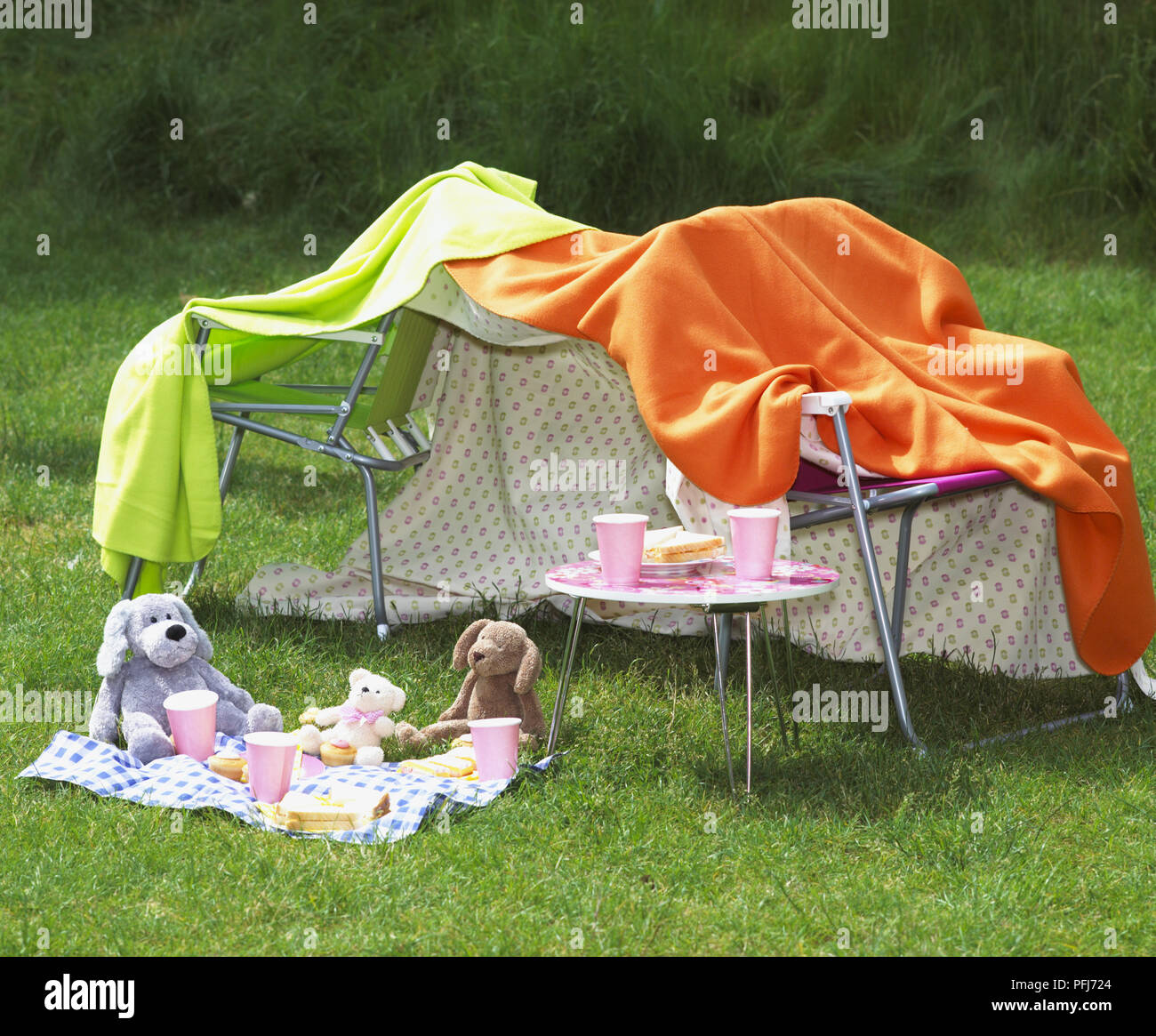 Tenda di fortuna realizzato da sedie e coperte accanto a un orsacchiotto picnic. Foto Stock