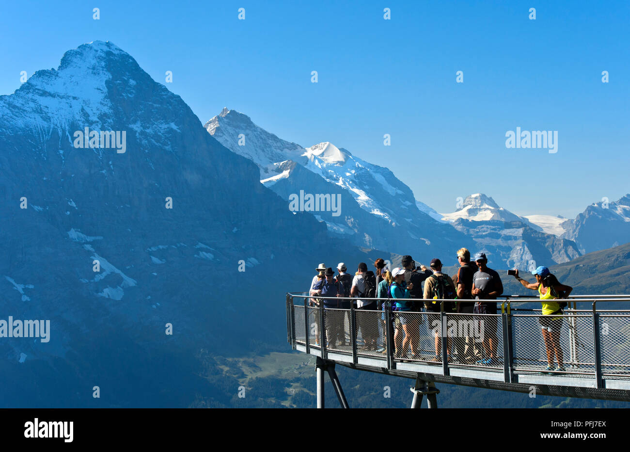 I turisti alla piattaforma di avvistamento guardando l'Eiger northface, prima scogliera a piedi da Tissot, Grindelwald, Svizzera Foto Stock