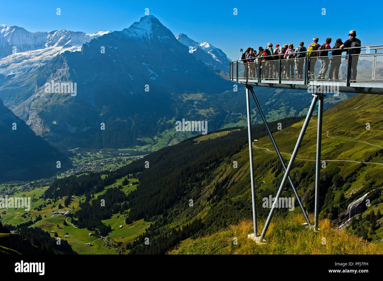 I turisti alla piattaforma di avvistamento alta sopra Grindelwald nella valle, Eiger northface dietro, prima scogliera a piedi da Tissot, Grindelwald, Svizzera Foto Stock