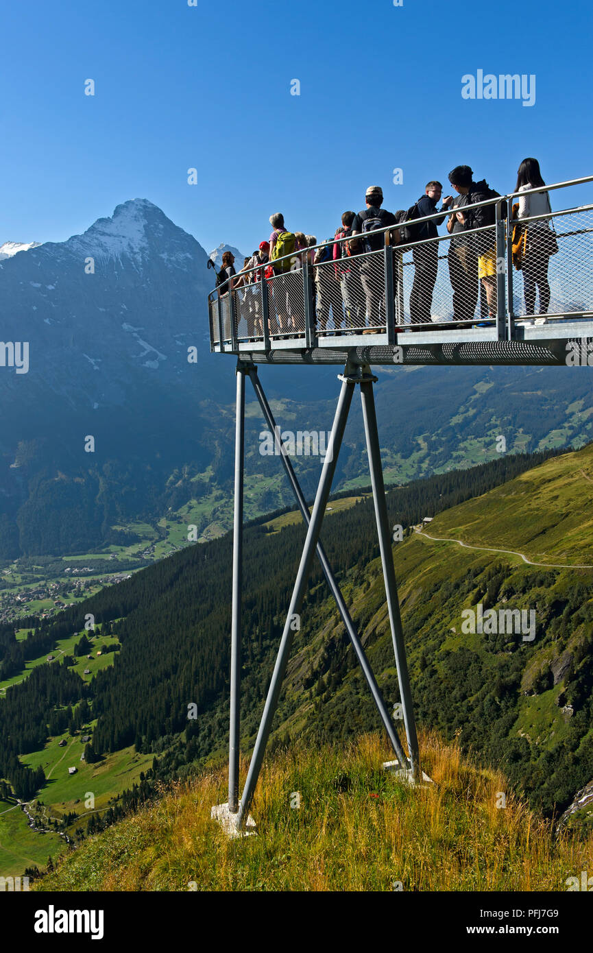 I turisti alla piattaforma di avvistamento alta sopra Grindelwald nella valle, Eiger northface dietro, prima scogliera a piedi da Tissot, Grindelwald, Svizzera Foto Stock