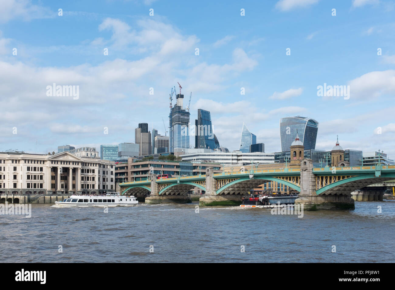 Southwark ponte che attraversa il fiume Tamigi a Londra con la City of London Financial District in background Foto Stock