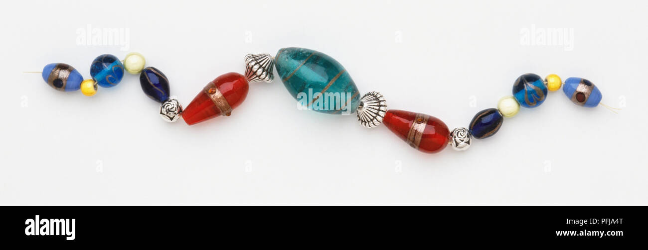 Perle assortite, rosso, blu e argento, su una stringa Foto Stock
