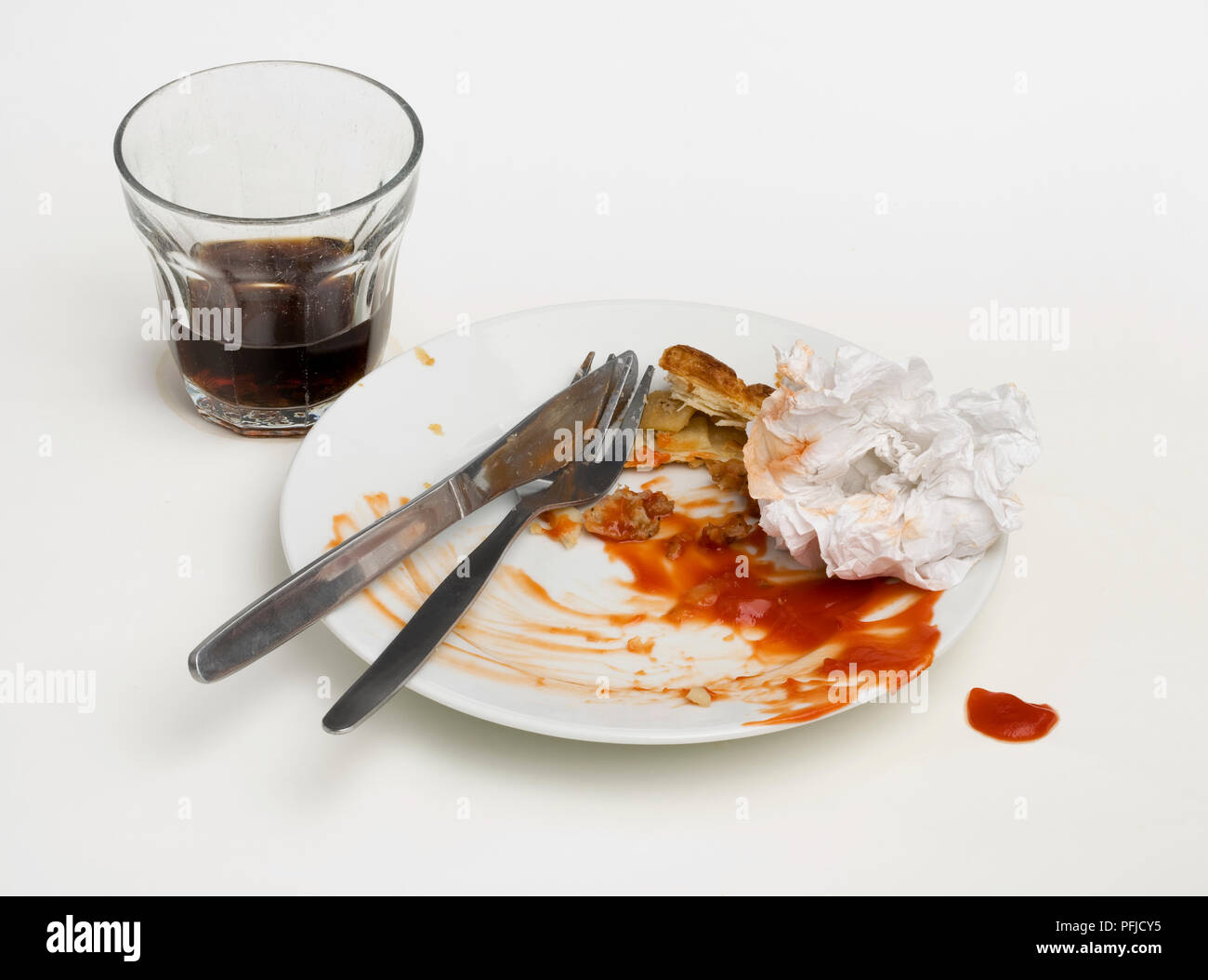 Piastra di sporco e posate, sgualciti igienico, soft drink in un bicchiere Foto Stock