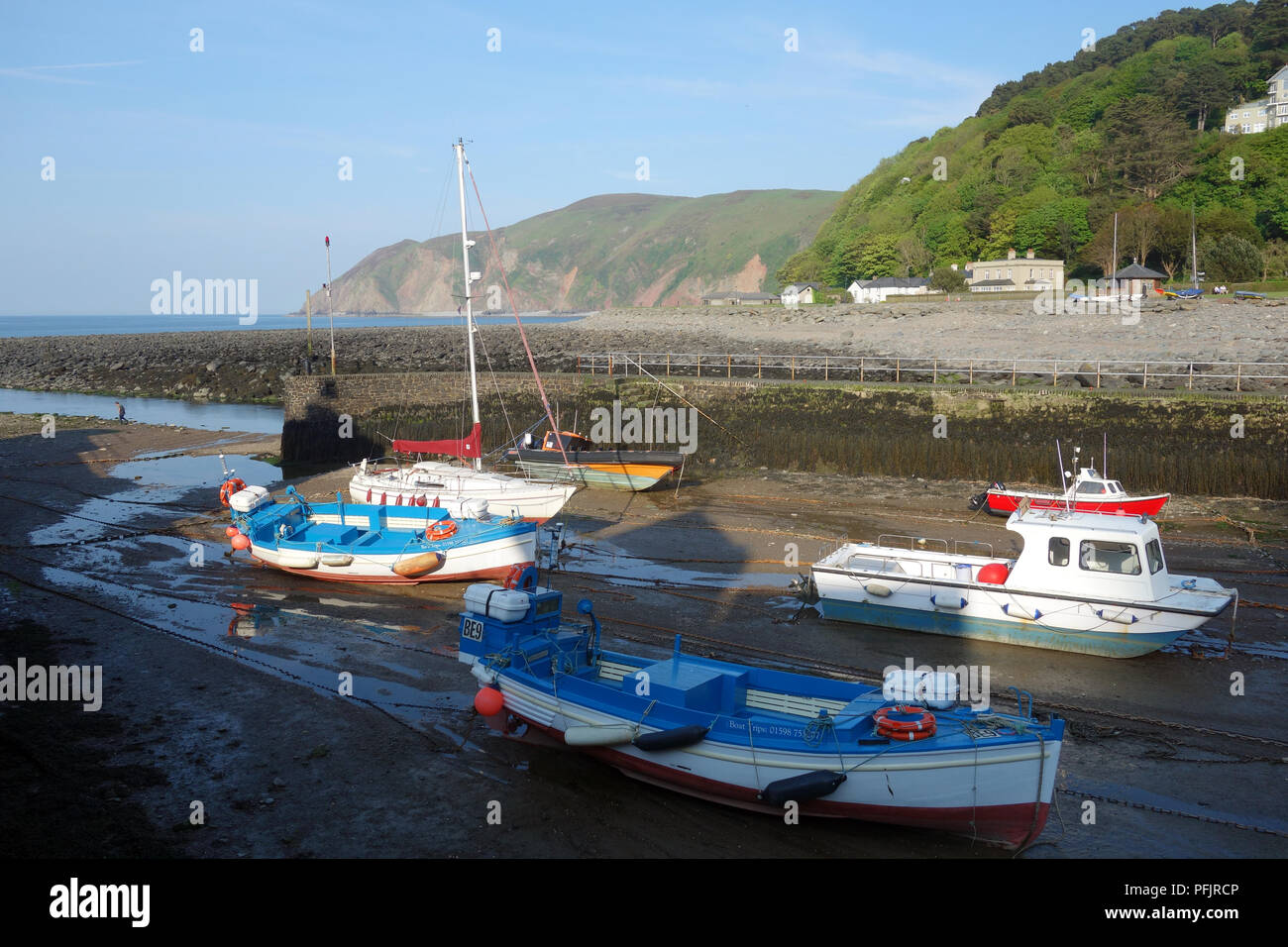 Barca a vela, barche da pesca e da diporto ormeggiata nel porto di Lynmouth al tramonto sul sud-ovest sentiero costiero, Somerset, Inghilterra, Regno Unito. Foto Stock