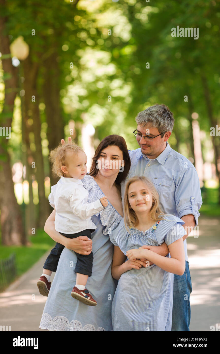 Felice famiglia con due bambini godersi il tempo nel parco Foto Stock