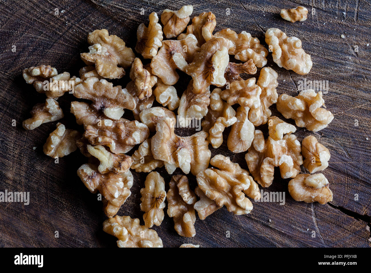 I gherigli di noci sul tagliere di legno sfondo direttamente dal di sopra Foto Stock