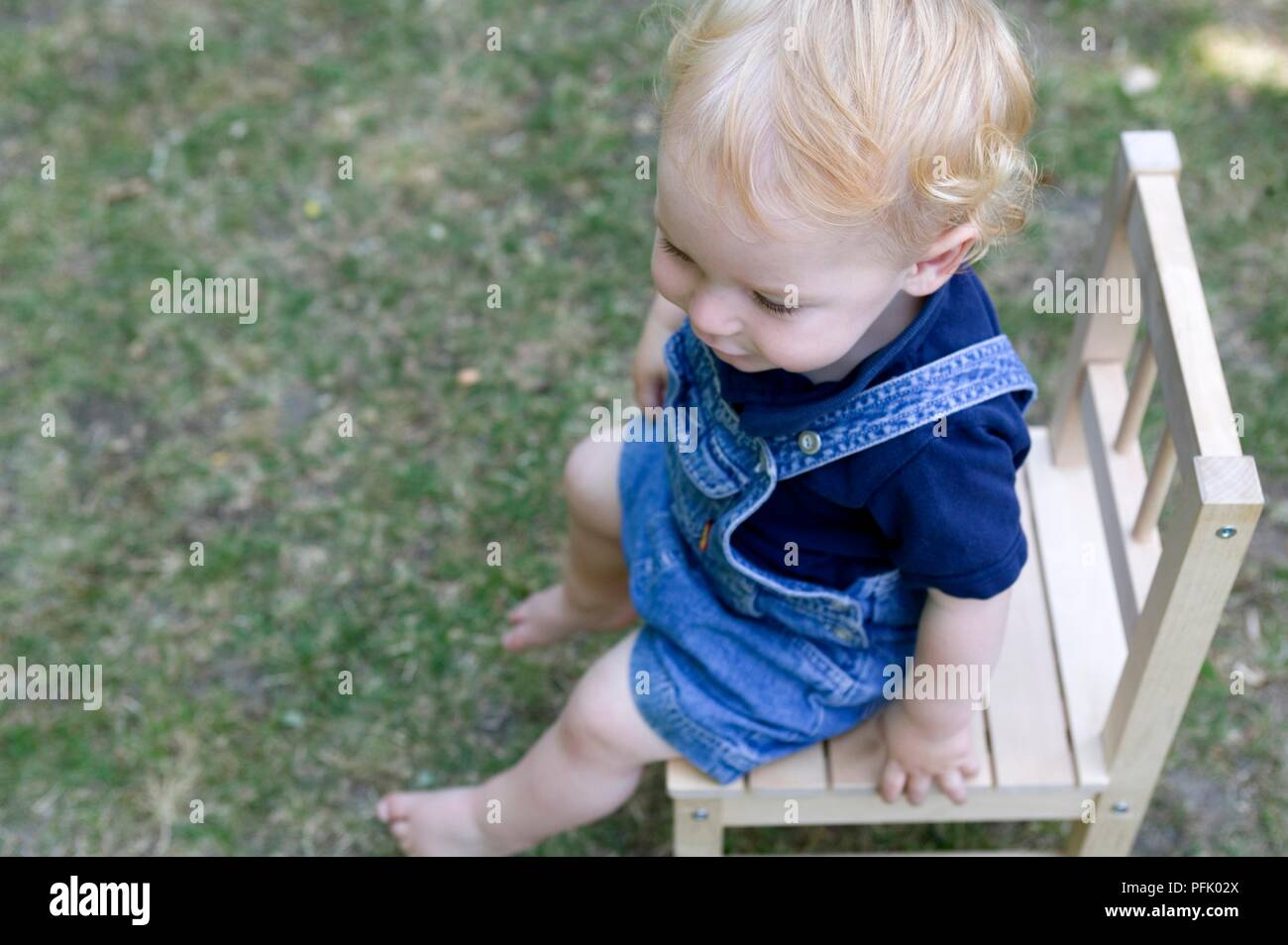 Blonde bimbo seduto su una sedia, close-up Foto Stock