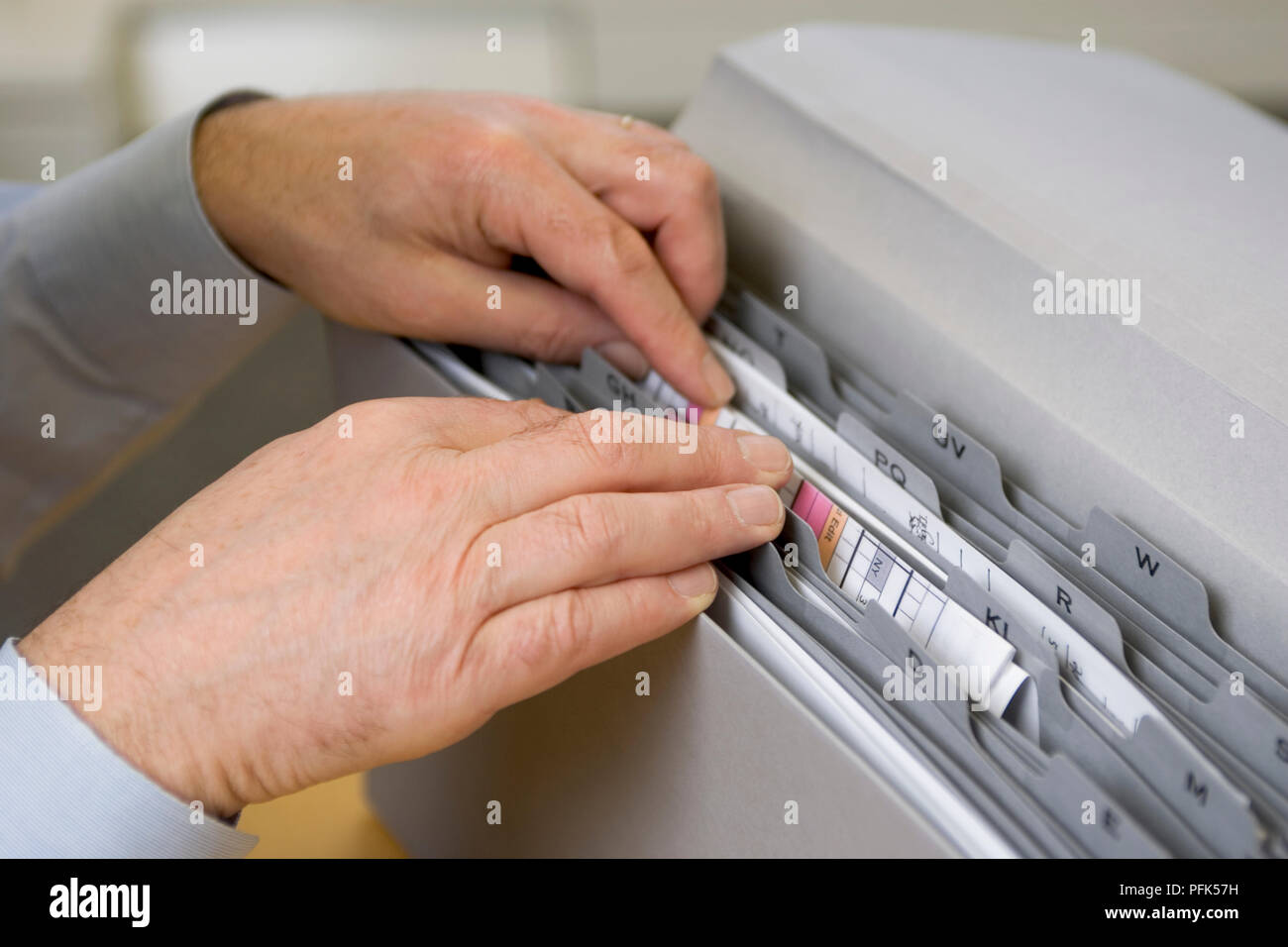 Coppia di mani attraverso la ricerca di file con divisori in ordine alfabetico Foto Stock