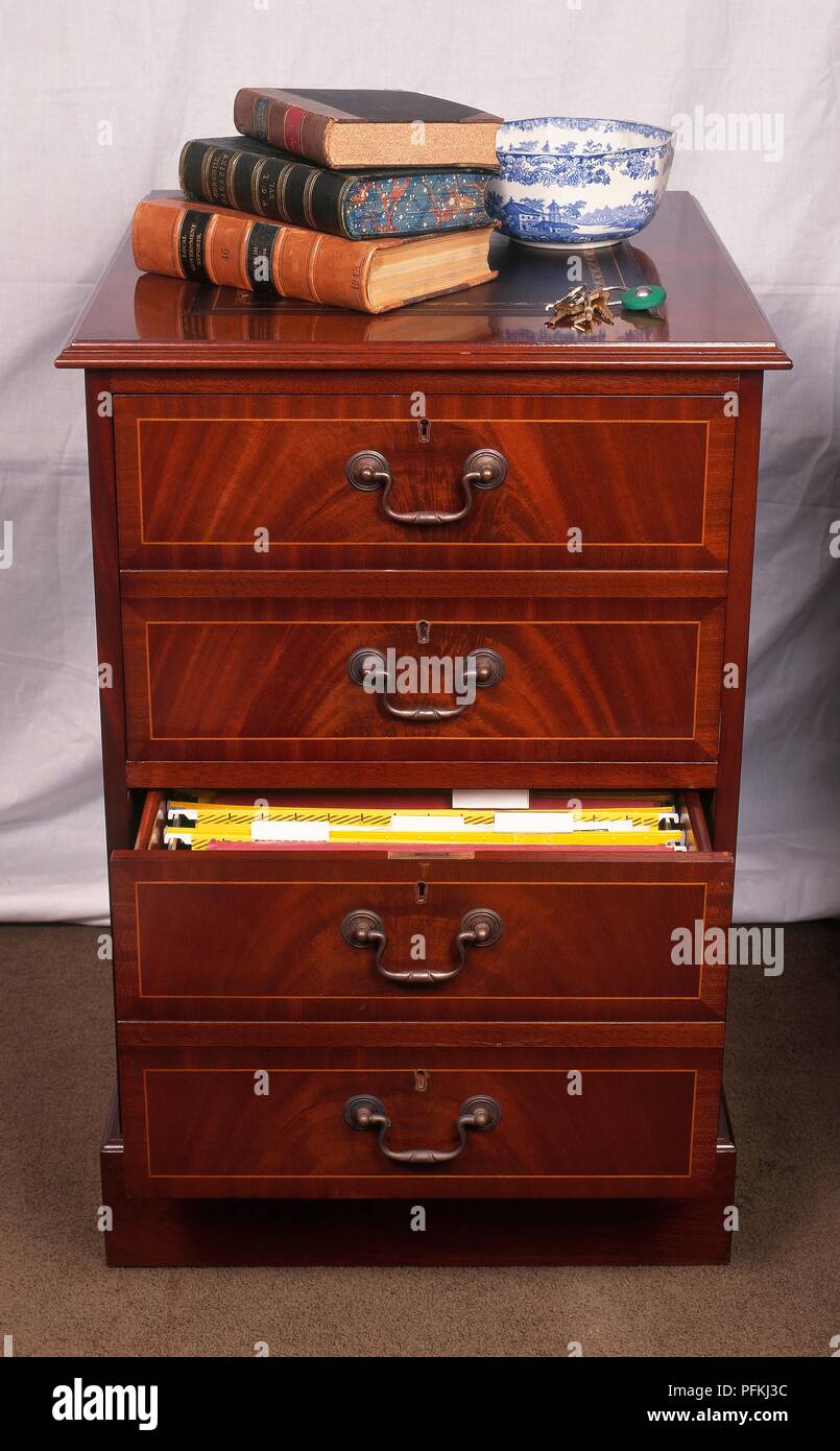 Cassettiera con libri, chiavi e ciotola sulla parte superiore e i file in  uno dei cassetti, vista frontale Foto stock - Alamy