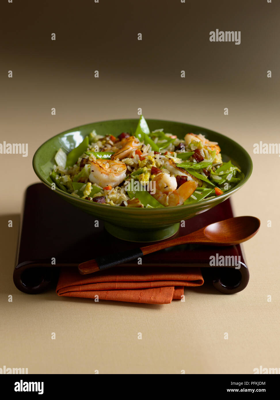 Ciotola di stir-riso fritto con salsiccia cinese, gamberi e mangetouts, con cucchiaio e Tovagliolo Foto Stock