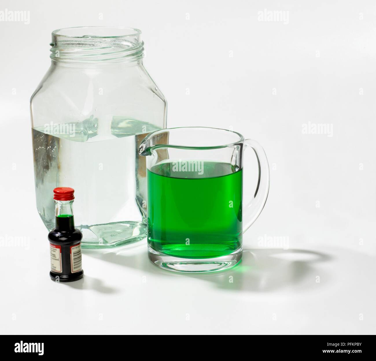 Acqua in aprire il vasetto di vetro, verde acqua in caraffa e bottiglia di verde colorante alimentare Foto Stock