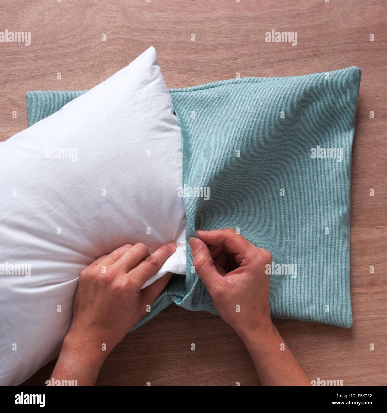 Inserimento di imbottitura nella fodera per cuscino, close-up Foto Stock