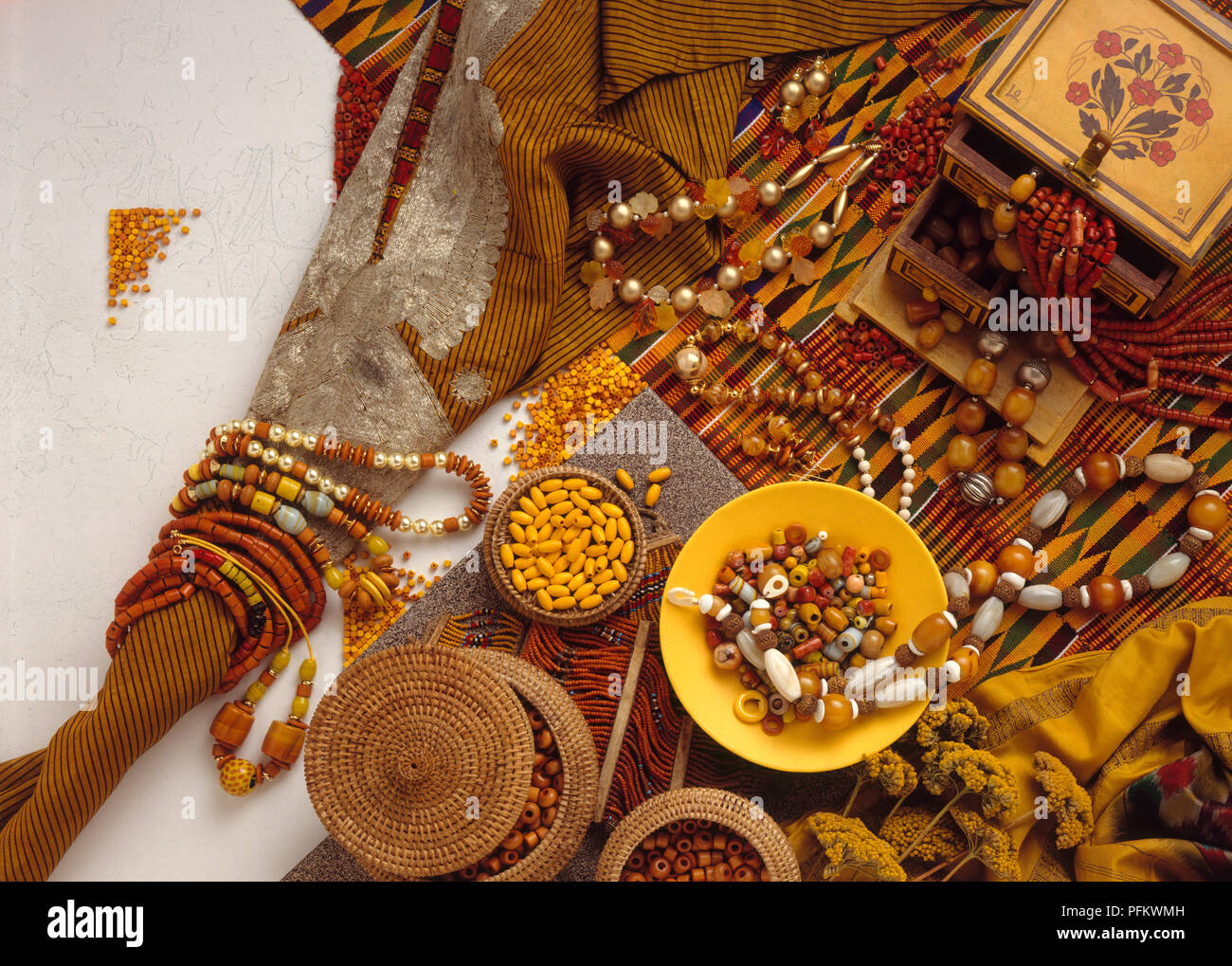 Tono di terra perle e gioielli etnici, steso su tessuto, su piastre, in scatole, vista da sopra Foto Stock