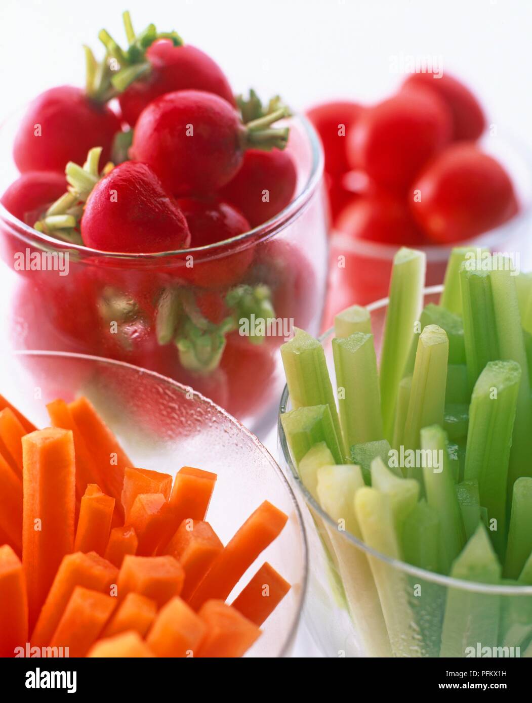 Ravanelli, bastoncini di carote, sedano e pomodori ciliegini, servito in bicchieri, close-up Foto Stock