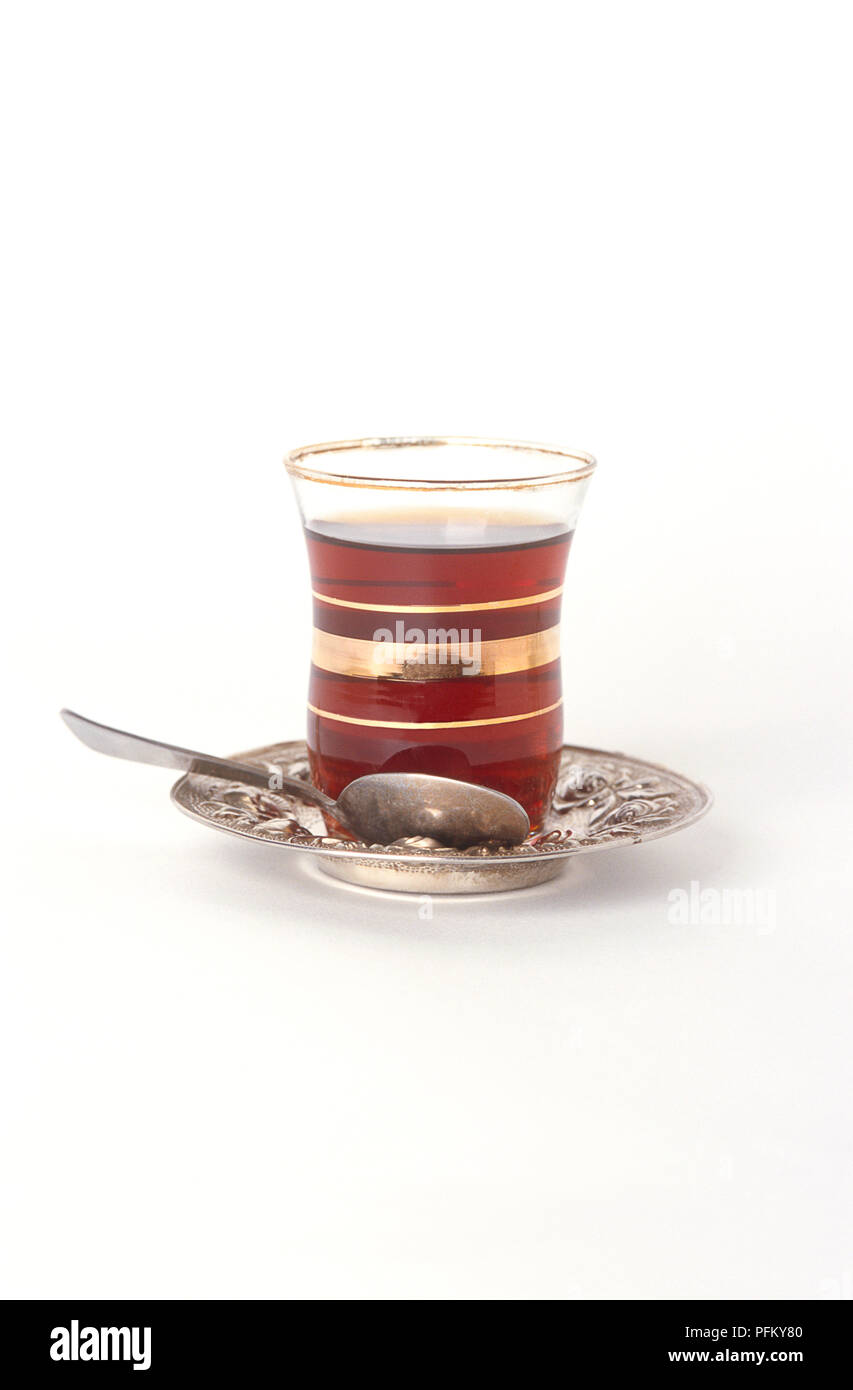 Bicchiere di tè turco su argento piattino, cucchiaio d'argento Foto Stock