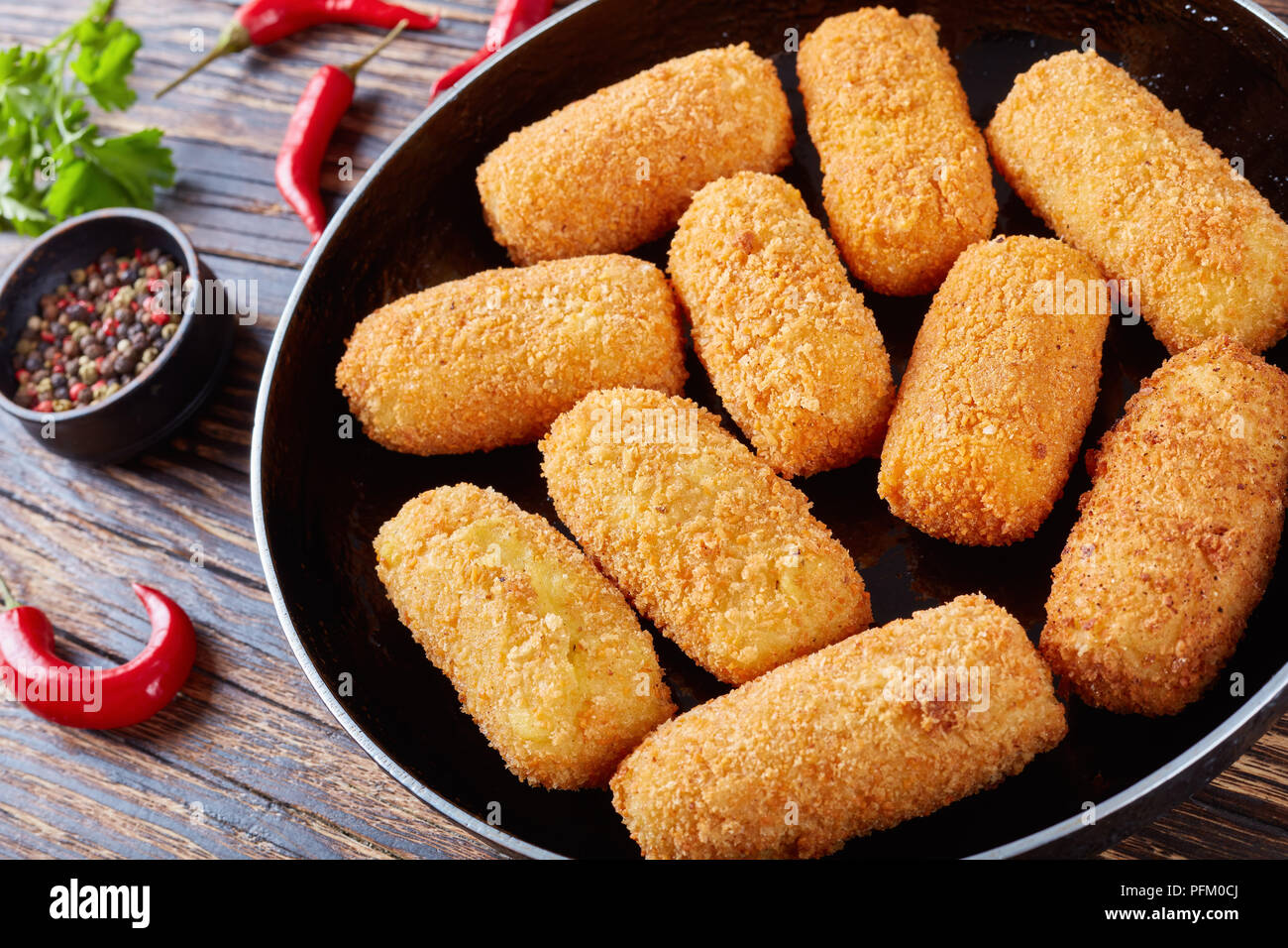 Close-up di deliziose spagnolo fritte crocchette di patate, croquetas su una padella su una tavola in legno rustico, orizzontale vista da sopra Foto Stock