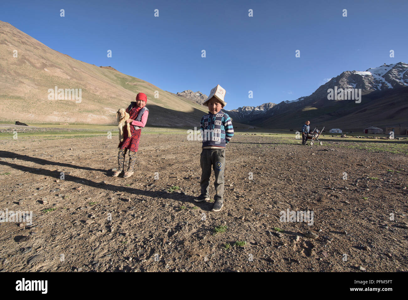 Herder kirghisa con il suo lamb e fratello, Pshart Valley, Tagikistan Foto Stock