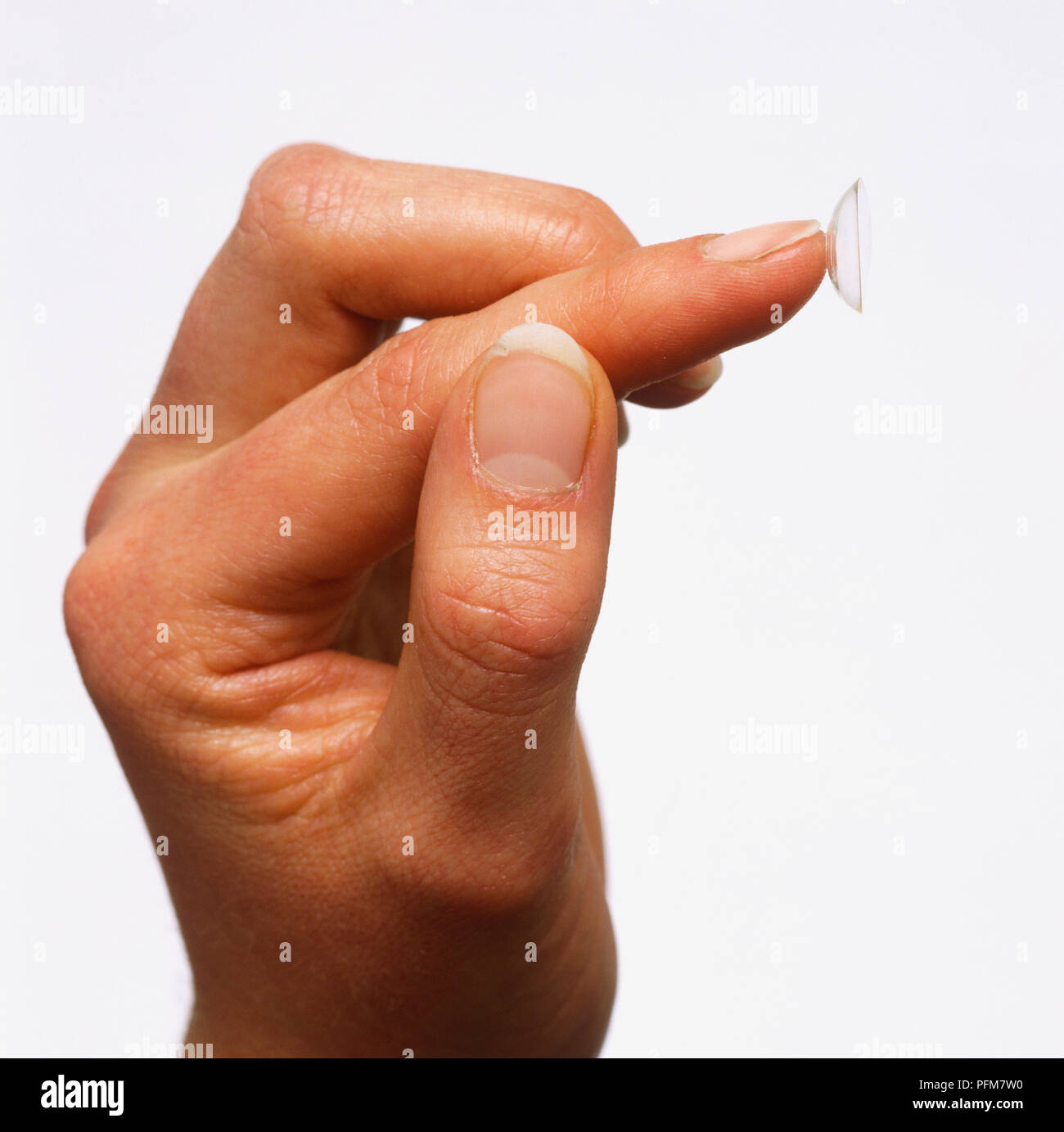 Mano con lente di contatto sulla punta del dito. Foto Stock