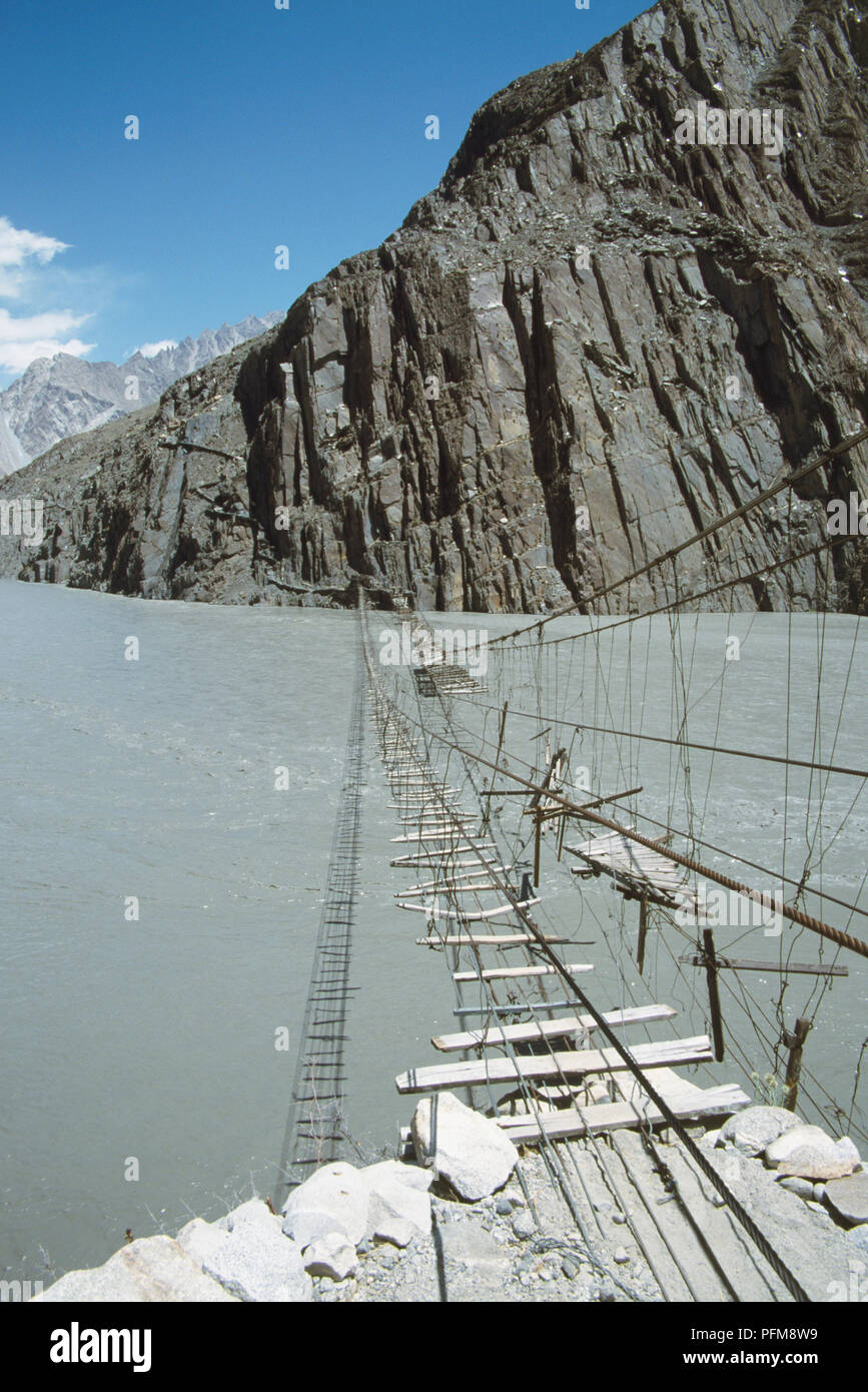 Legno, non particolarmente sicuro cercando in legno ponte di sospensione, in cattive condizioni, oltre il Fiume Hunza. Foto Stock