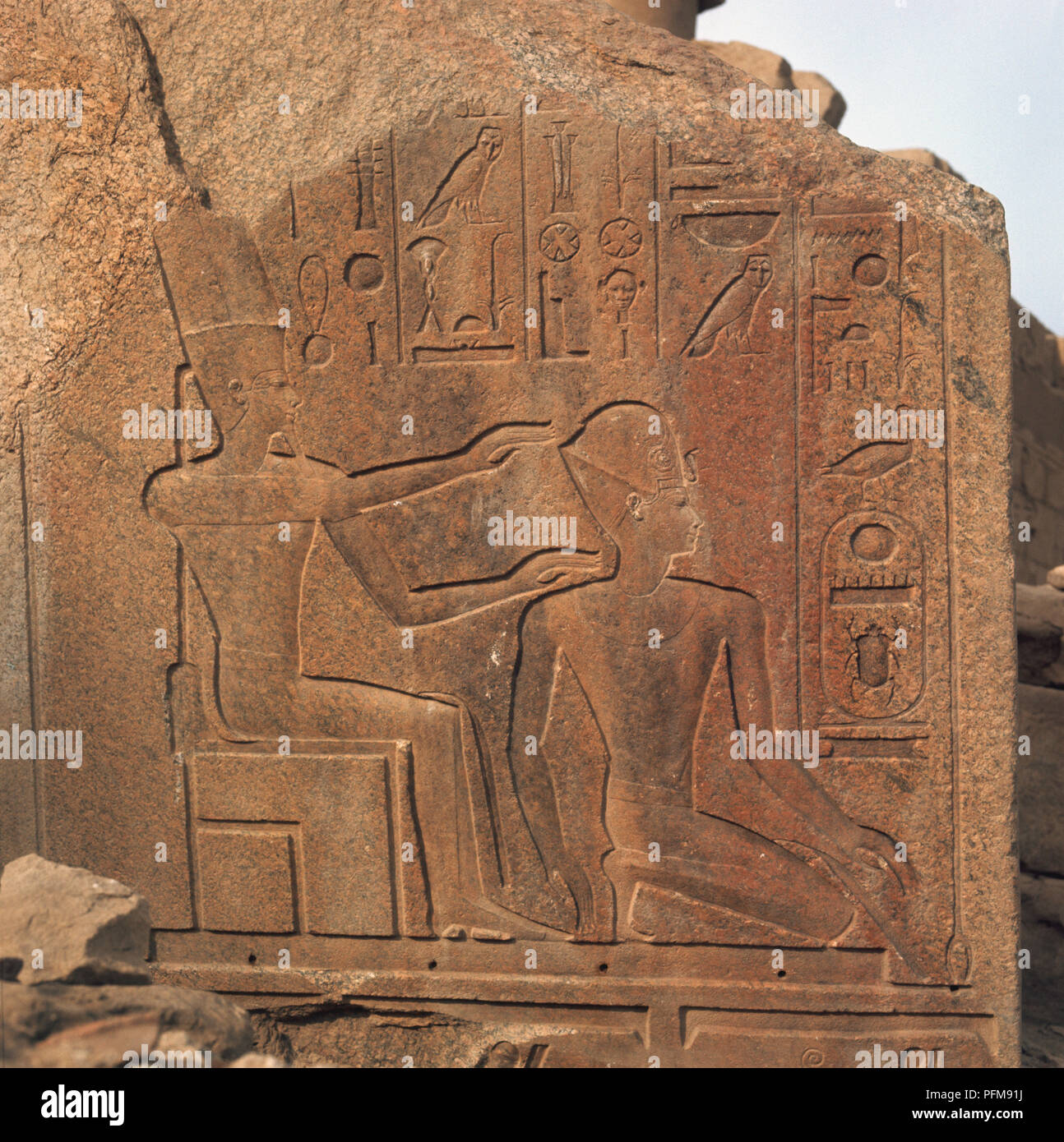 L'Egitto, il Tempio di Karnak complessa, frammento di pietra con sculture raffiguranti Amon Ra seduta e di Ramses II in ginocchio. Foto Stock