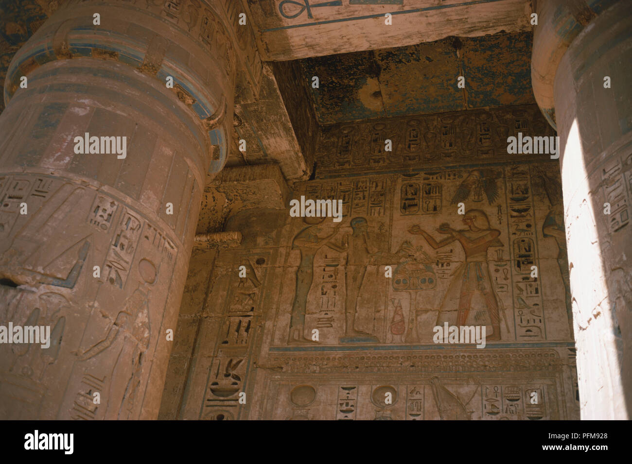 Egitto, spalliere pareti dipinte e scolpite le colonne all'interno del tempio di Ramesse III a Medinet Habu nell'antica capitale egiziana di Tebe. Foto Stock