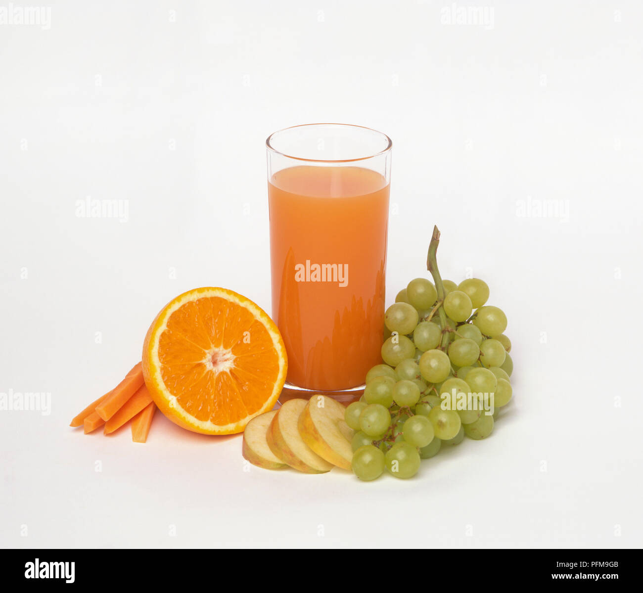 La metà di un'arancia, bicchiere di succo di arancia, fette di carota e apple e il grappolo di uva Foto Stock