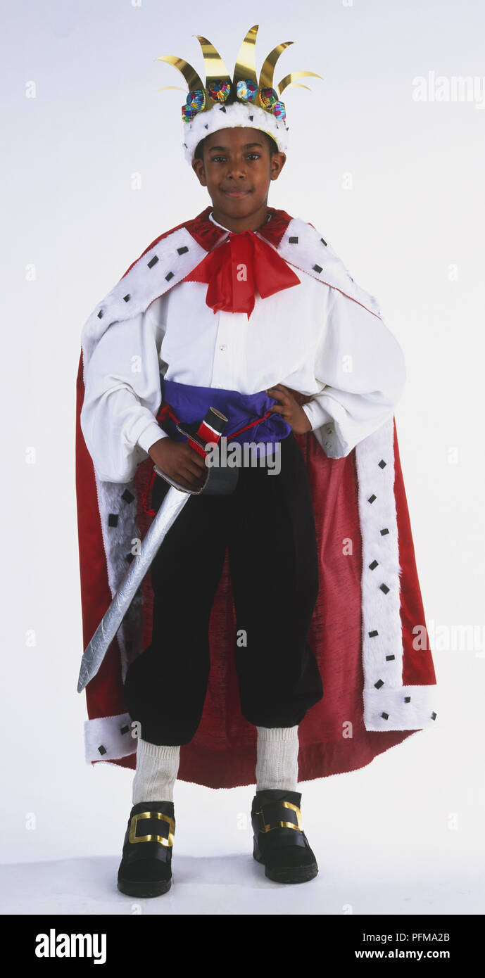 Ragazzo vestito come un nobile re, indossando una corona e che tiene una spada, vista frontale Foto Stock