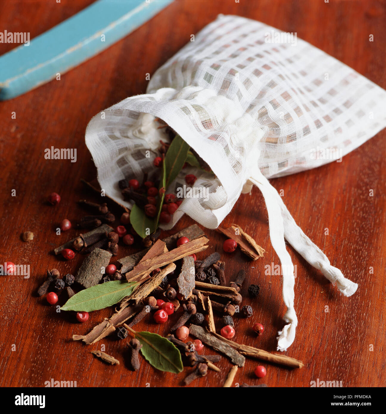 Le erbe aromatiche, le spezie e bacche di fuoriuscita del bianco borsa a cordoncino sulla superficie di legno, pot-pourri. Foto Stock