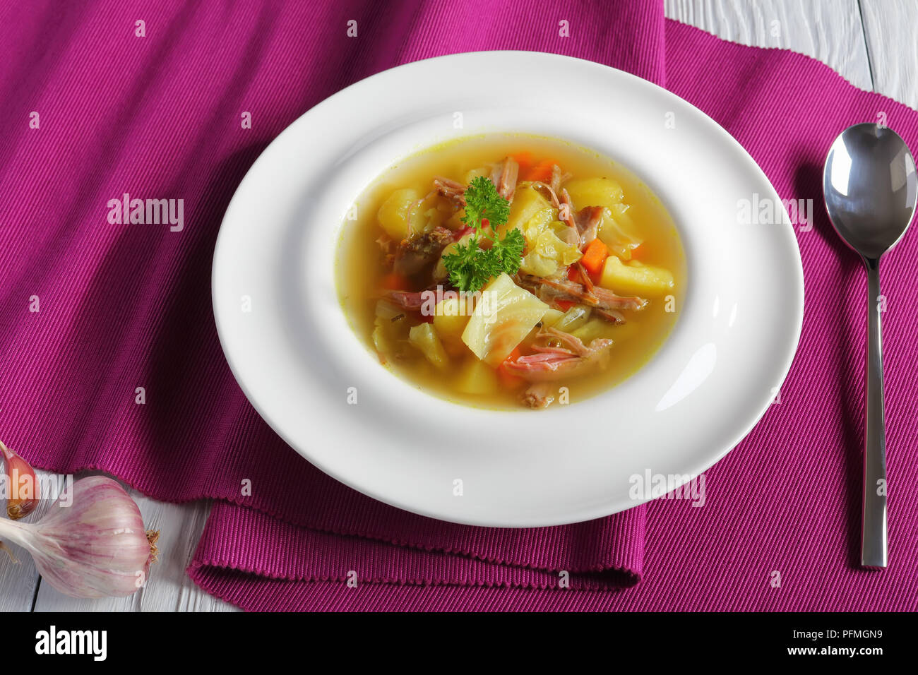Classica zuppa islandese di Shredded carne di agnello, spezie e verdure o kjotsupa servita nella scodella sulla tabella MAT con cucchiaio d'argento su legno bianco ta Foto Stock