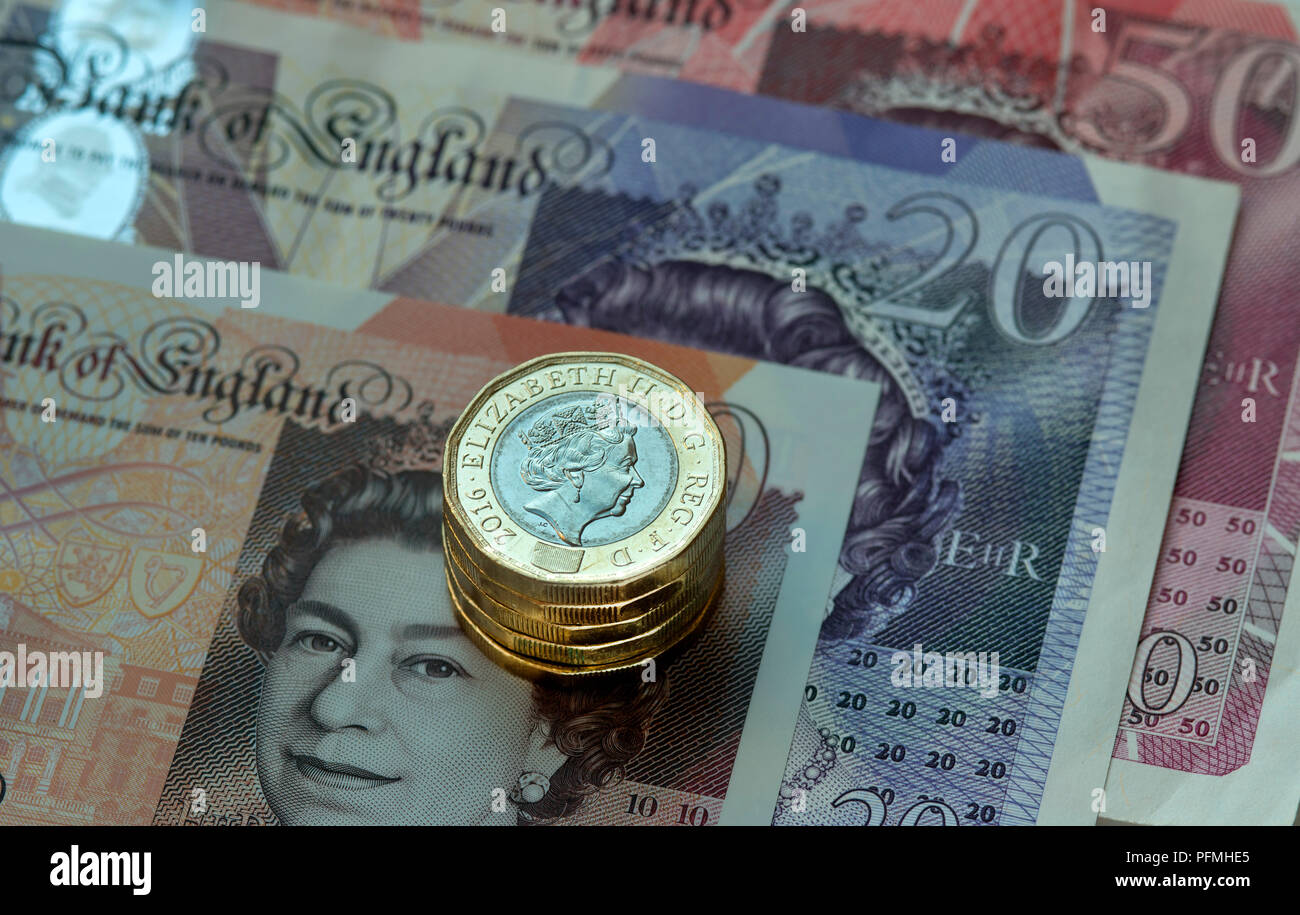 New British (GBP) pound monete in appoggio su £50, £20, £10 pound note. Foto Stock