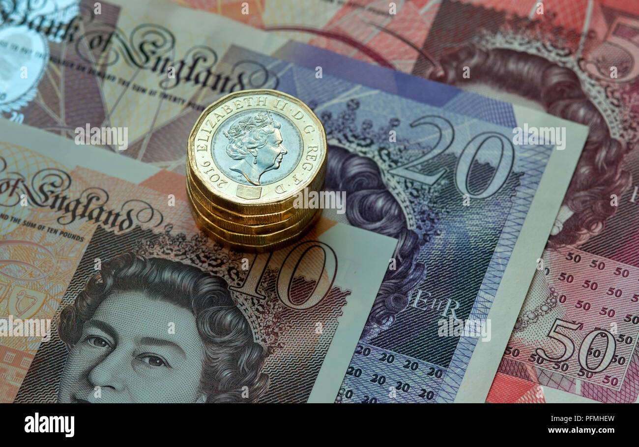 New British (GBP) pound monete in appoggio su £50, £20, £10 pound note. Foto Stock