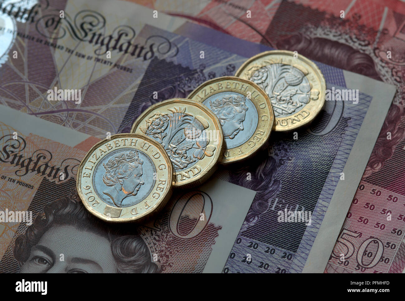 New British (GBP) pound monete in appoggio su £50, £20, £10 pound note. Foto Stock