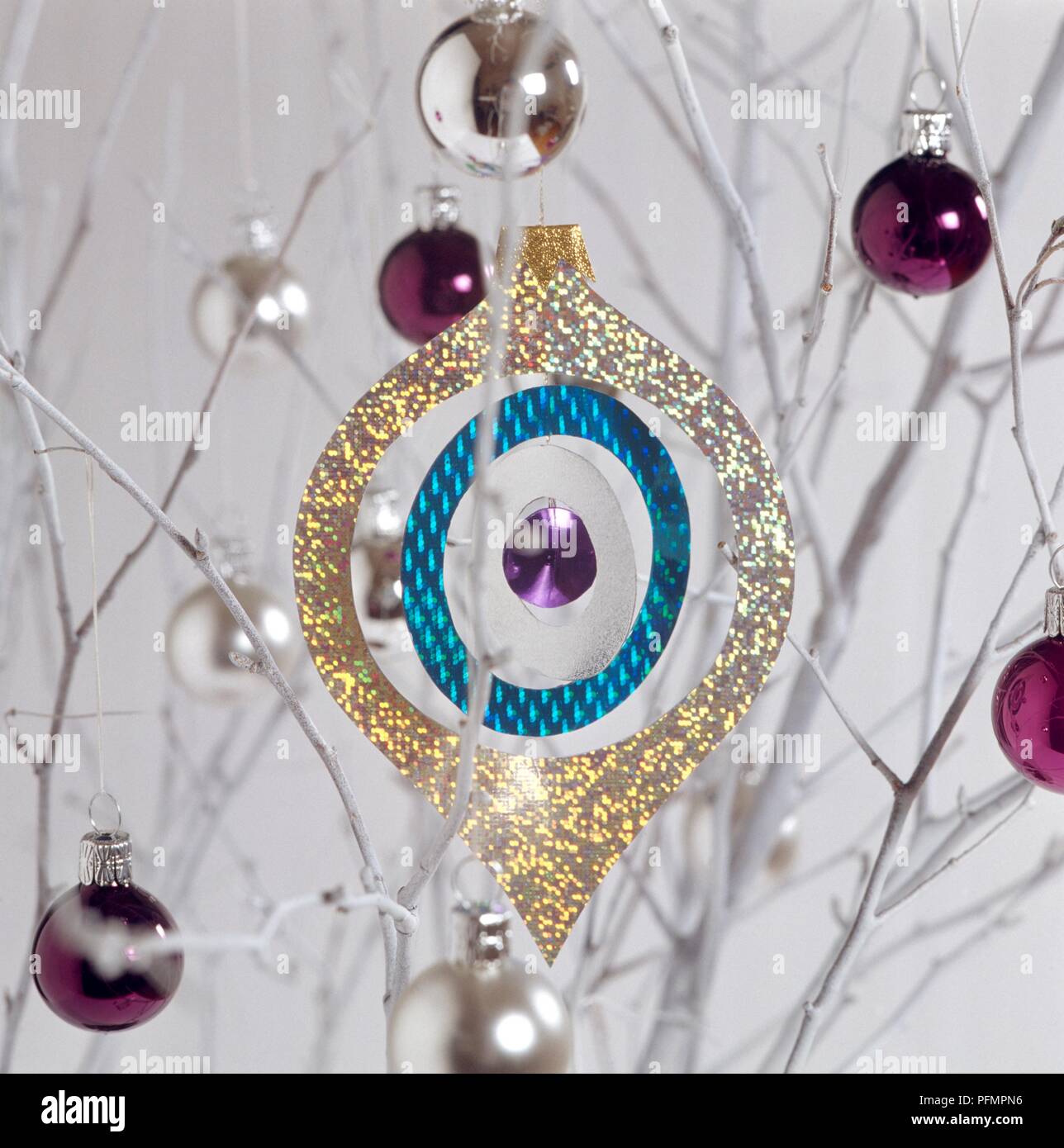 Decorazione di Natale appeso su albero circondato da viola e argento baubles Foto Stock