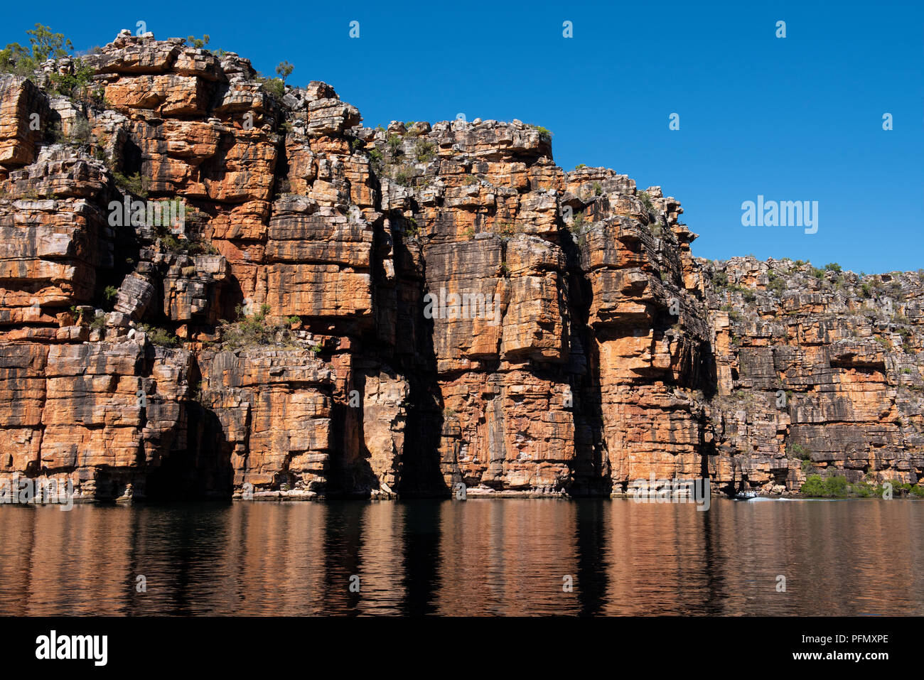 Australia, Western Australia Kimberley Costa, Koolama Bay. Tipica roccia rossa riflessioni lungo il King George fiume. Zodiac con avventura turisti. Foto Stock