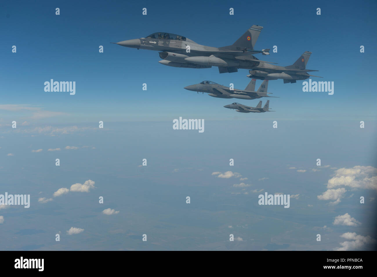 Il rumeno F-16 Fighting Falcons volare in formazione con il Massachusetts Air National Guard 131Expeditionary Fighter Squadron F-15C aquile al di sopra di Bucarest, Romania, 20 Agosto, 2018. Gli Stati Uniti lavora a stretto contatto con la Romania su una vasta gamma di sfide globali, tra cui promuovere la pace, la sicurezza e la prosperità economica. (U.S. Air Force foto di Senior Airman Alba M. Weber) Foto Stock